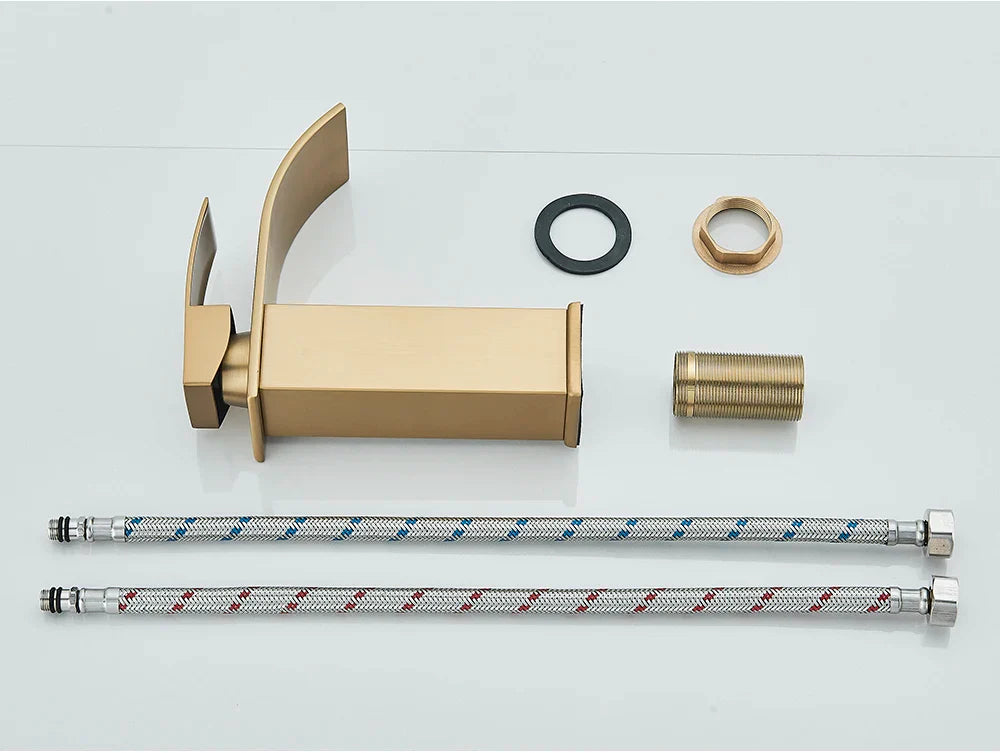 Gold-toned bathroom sink faucet brass deck mount with sleek curved spout and stainless steel rectangular base