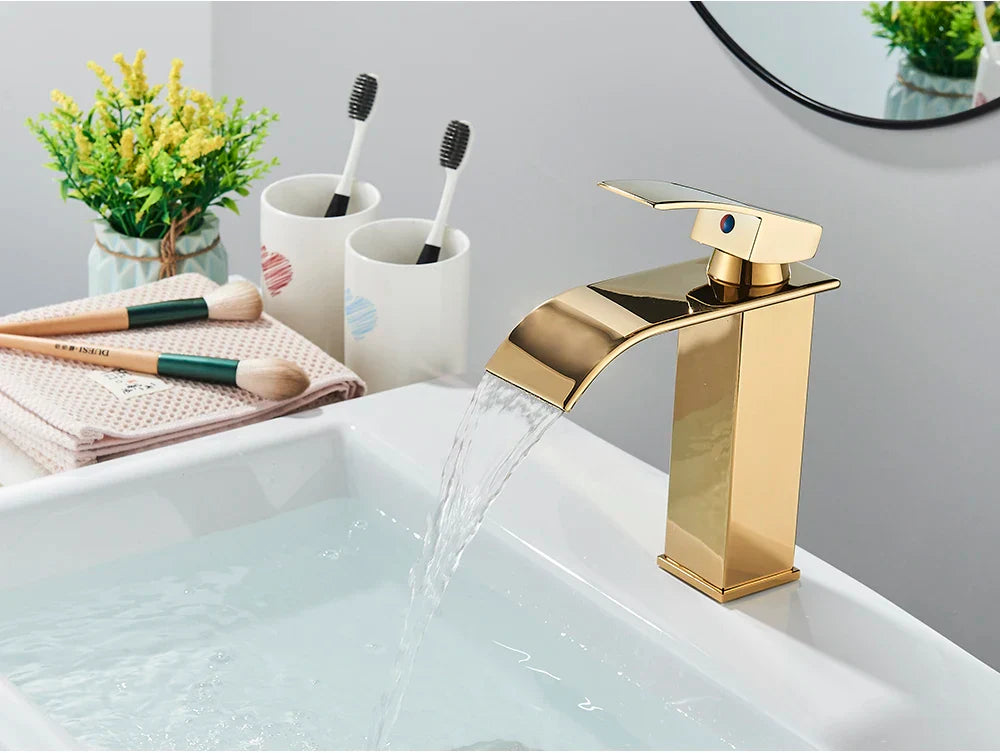 Gold-colored modern bathroom sink faucet with stainless steel waterfall deck mount and polished brass finish