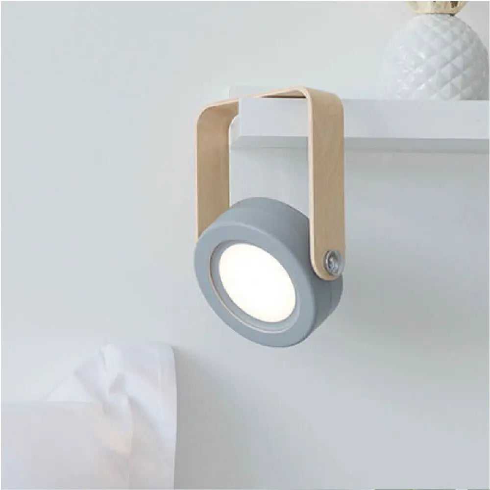 Gray circular battery-operated wall sconce lantern with light wood handle for versatile indoor lighting