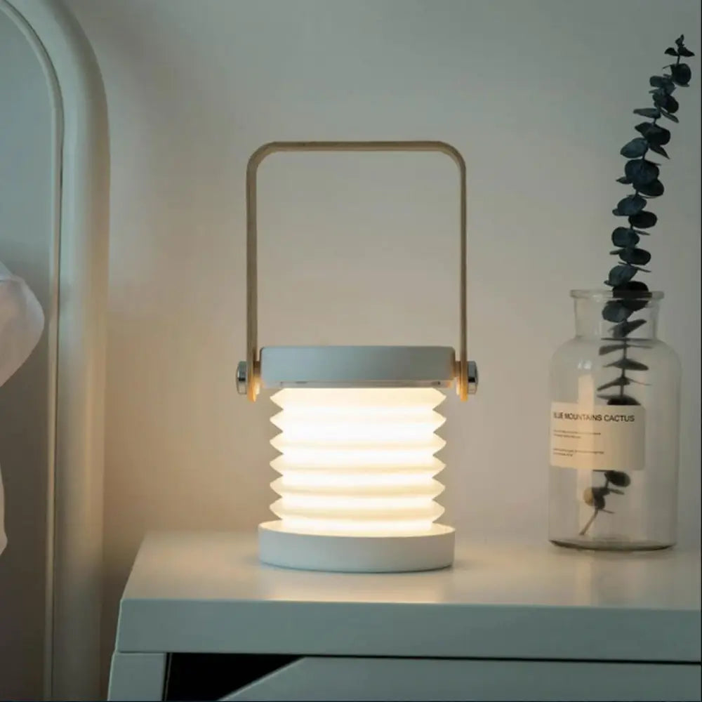 A sleek modern white battery-operated wall sconce lantern with a metal handle and warm ambient lighting