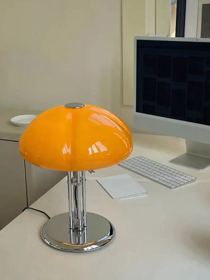 Vibrant orange bauhaus medieval table lamp with glossy acrylic shade and polished chrome base for bedroom atmosphere