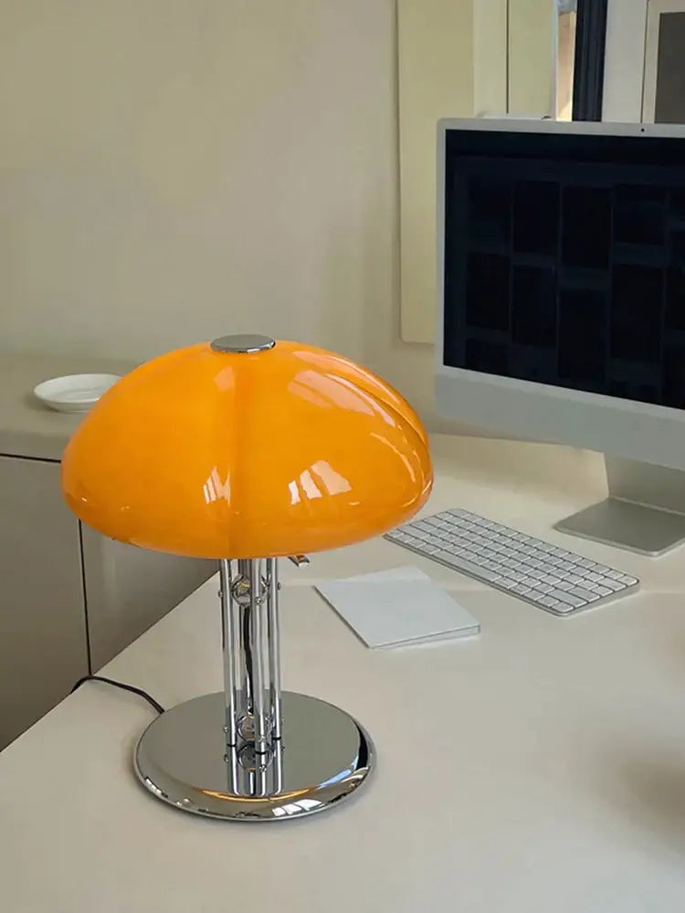 Vibrant orange bauhaus medieval table lamp with glossy acrylic shade and polished chrome base for bedroom atmosphere