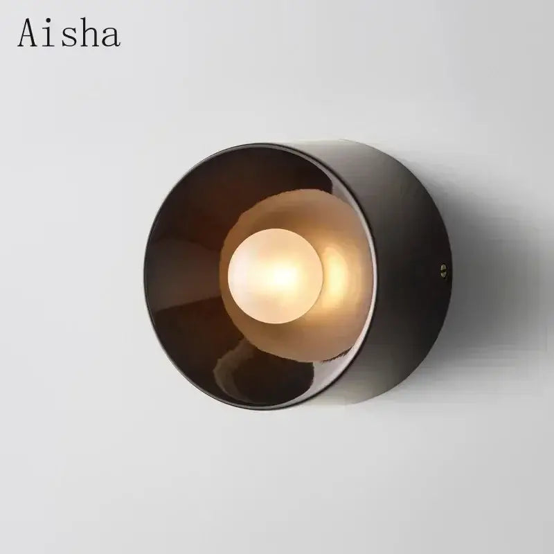 A sleek black bauhaus metal wall lamp with a warm glowing bulb ideal for living room led sconce lighting