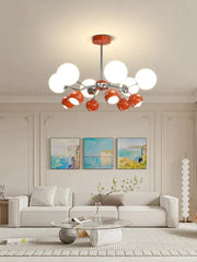 Modern lasha pendant light with chrome finish and spherical white and orange glass shades for dining room use