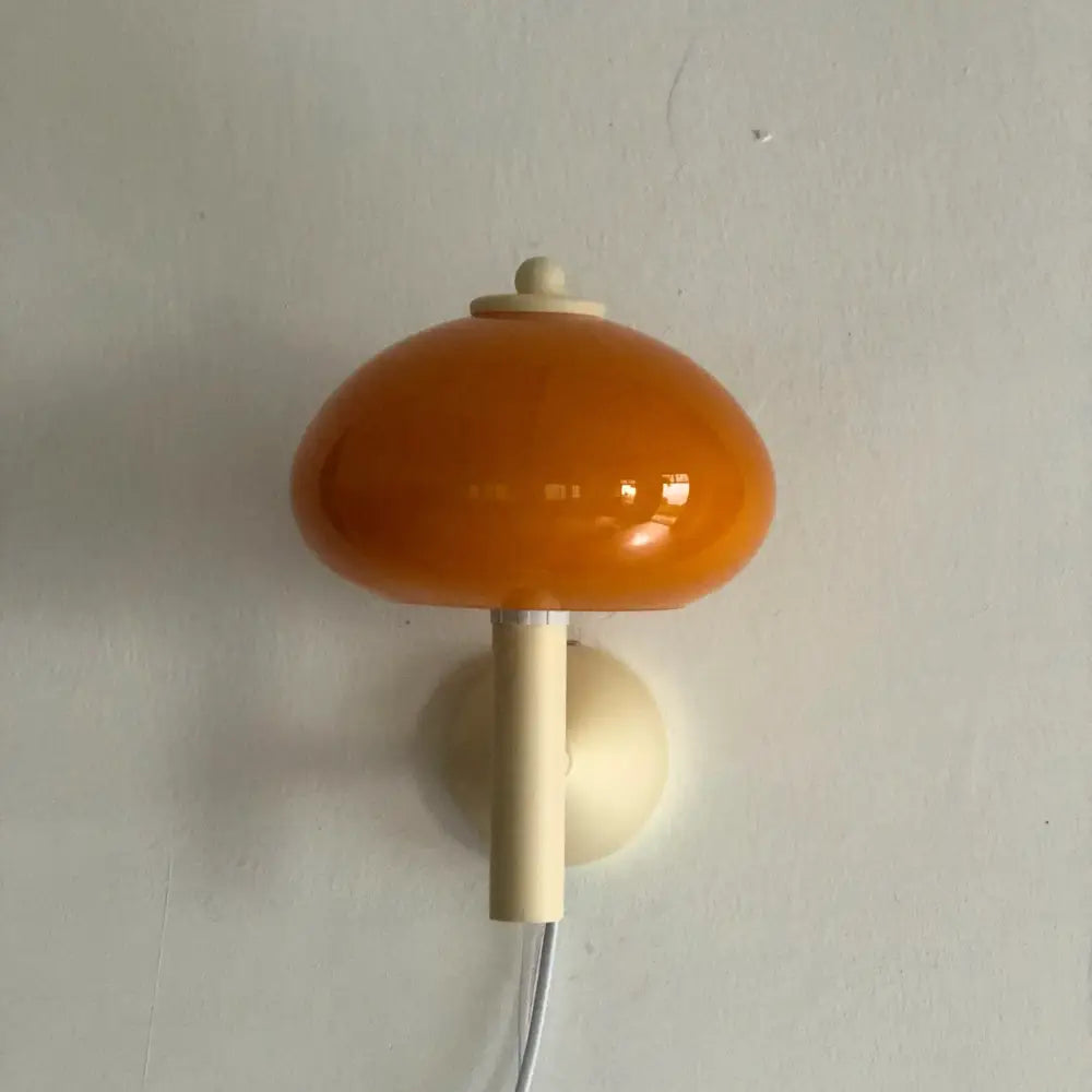 A glossy orange wall light with a cream mushroom glass base and stem from decorbites cream mushroom collection