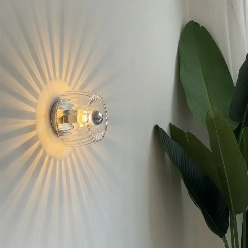 Bauhaus glass e14 wall lamp with ribbed clear glass sconce and metallic base emitting warm radial light for living room