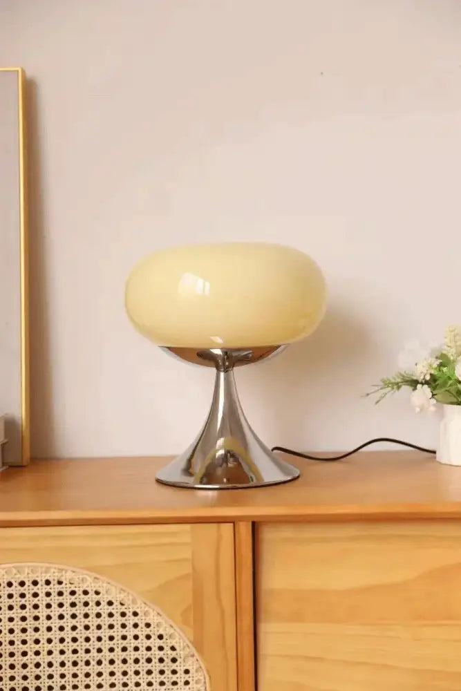 Cream-colored glossy glass led table lamp with sleek chrome base ideal for living room use