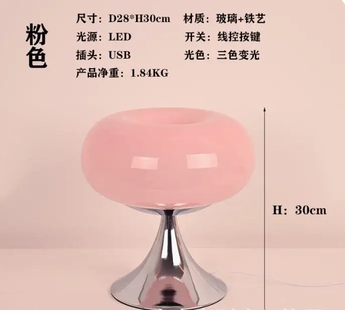 A sleek translucent pink glass led table lamp with polished chrome base and stem for living room use