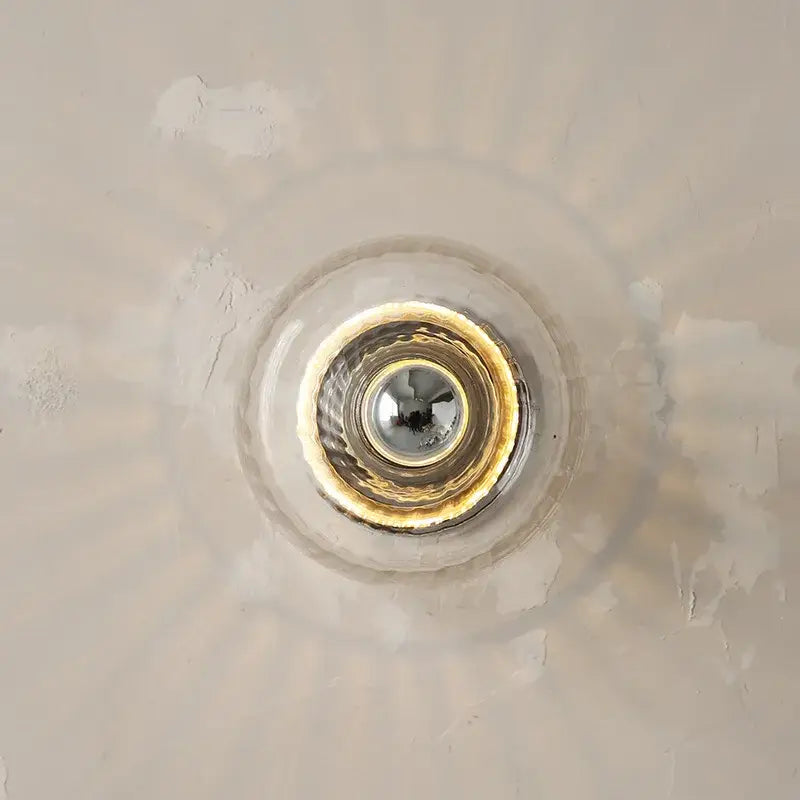 Clear glass bauhaus led wall sconces with gold-toned metallic rim and reflective center for aisle lighting