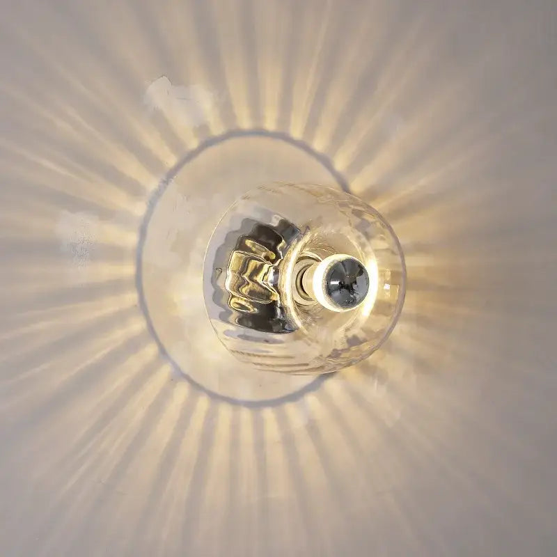 Clear glass bauhaus led wall sconces with metallic base and ridged design for aisle lighting