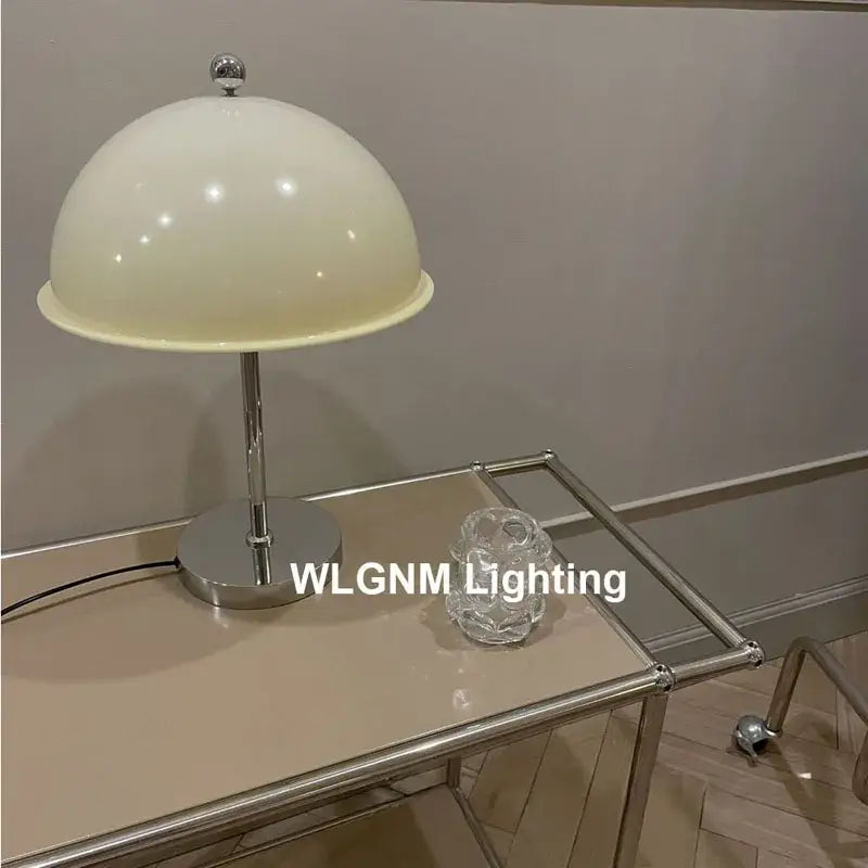 Cream-colored dome-shaped bauhaus mushroom table lamp with polished chrome base and stem for bedroom night light