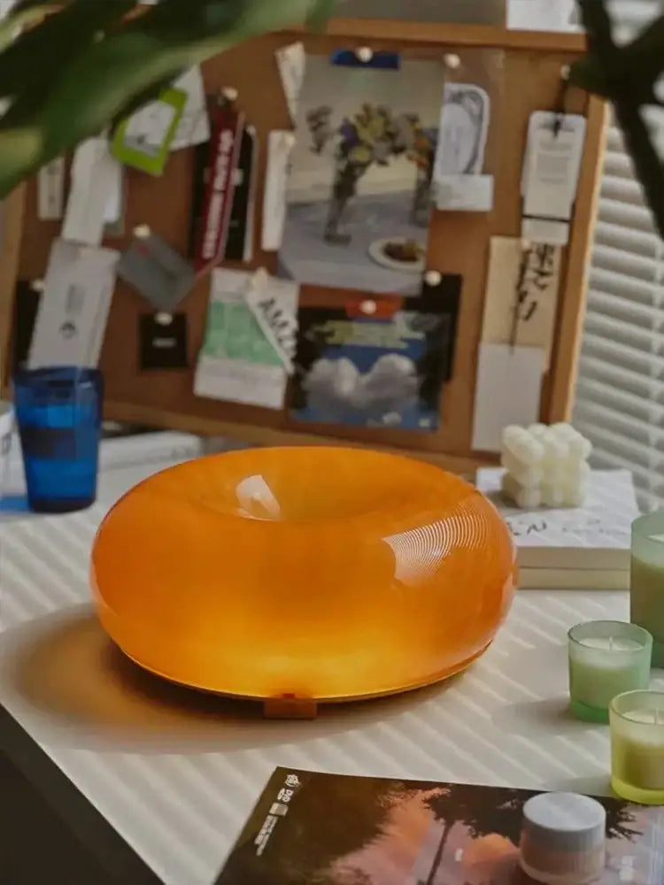 A translucent orange decorbites donut wall lamp with a smooth glossy finish for bedroom atmosphere lighting
