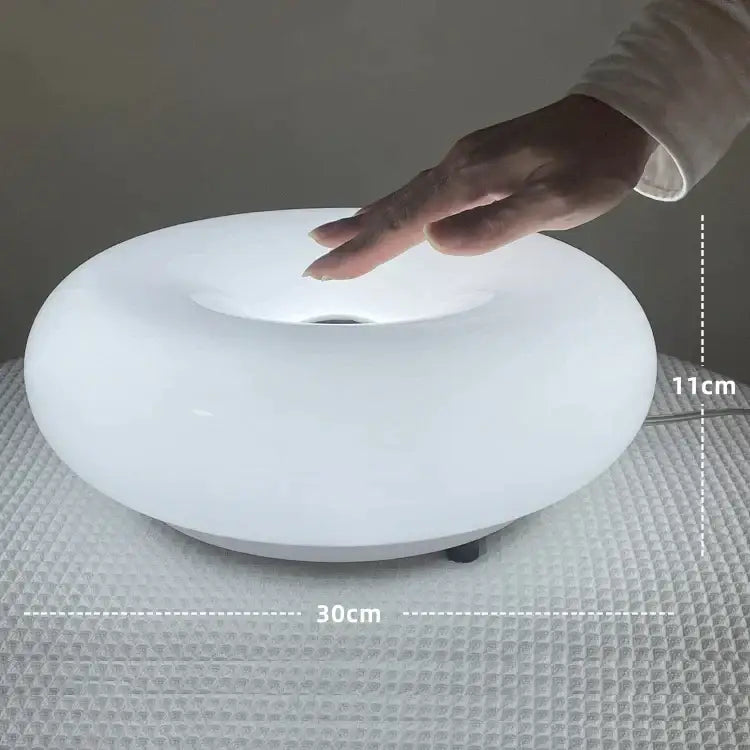 A sleek white oval led table lamp with glossy finish and illuminated center for decorbites donut wall lamp use