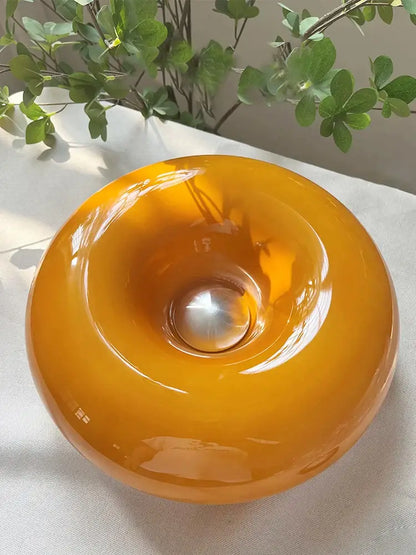 Glossy amber glass wall lamp with a metallic sphere center in Bauhaus orange decorbites donut wall lamp design
