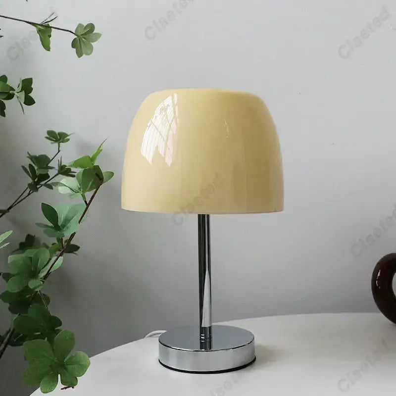 Cream-colored glossy ceramic lampshade on chrome base bauhaus retro table lamp for bedroom use