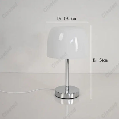 A sleek white glossy lampshade atop a polished chrome base on a bauhaus retro table lamp for modern interiors