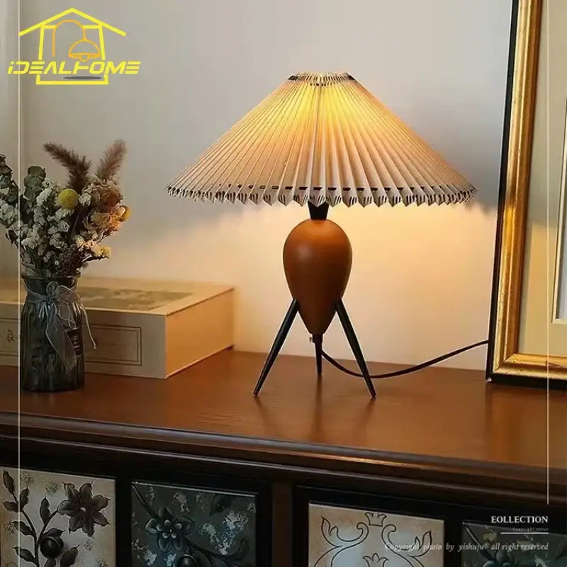 Warm-toned bauhaus pleated wood table lamp with fan-shaped shade and tripod base for bedroom desk lighting