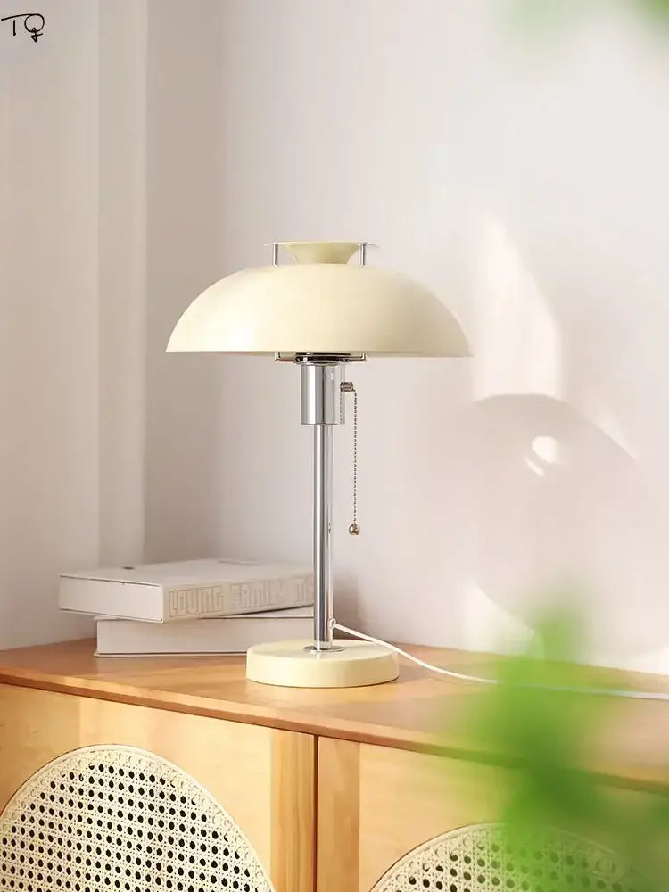 Cream-colored minimalist bauhaus led table lamp with sleek chrome stem and base for bedroom use