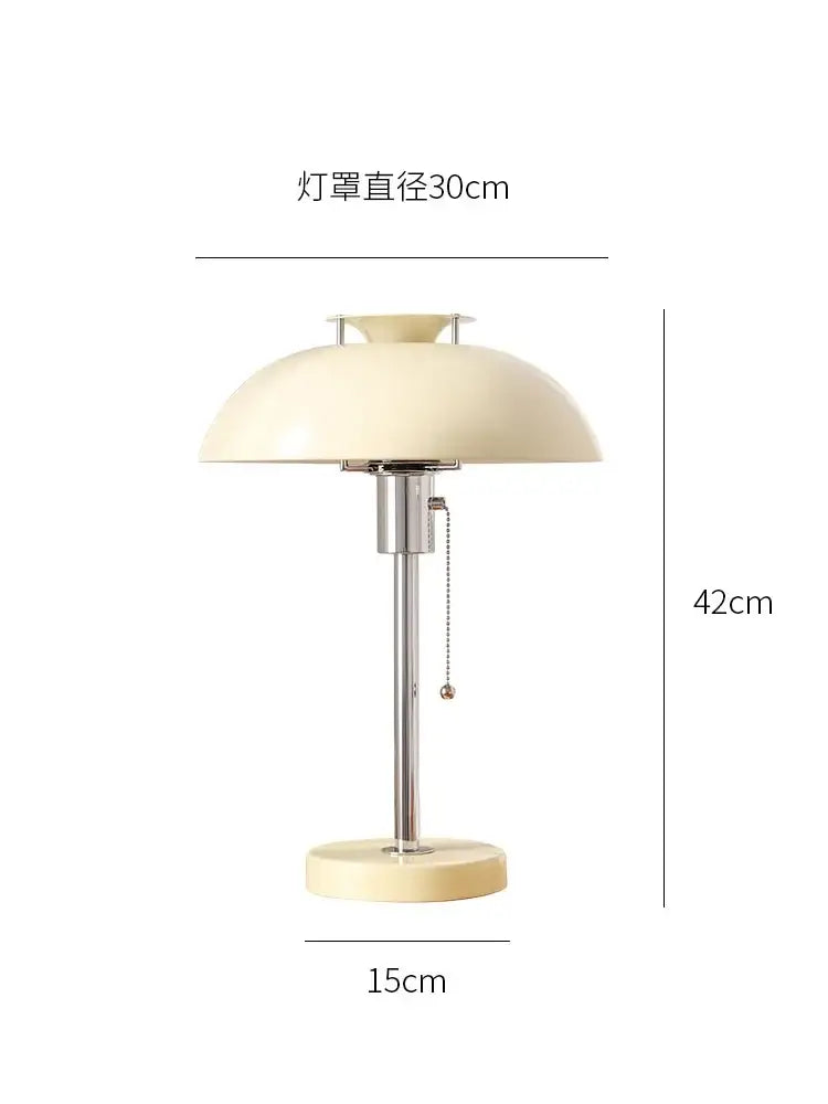 Cream-colored dome-shaped lampshade with chrome stem and base on bauhaus red glossy ceramic led table lamp for bedroom
