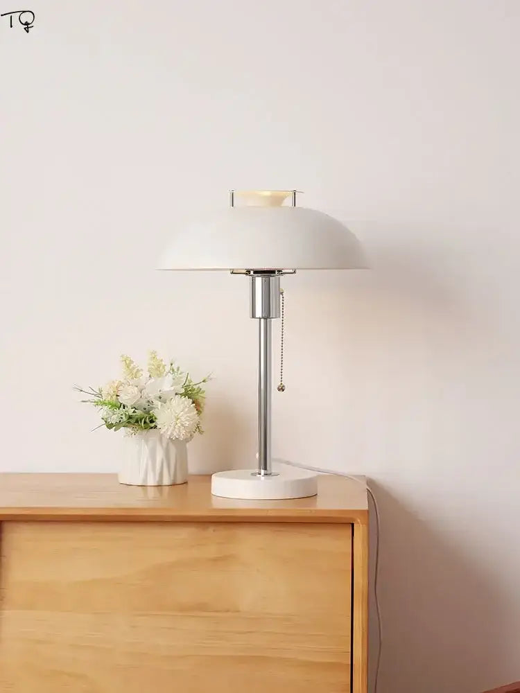 A sleek white ceramic bauhaus led table lamp with polished chrome stem and minimalist dome shade for bedrooms