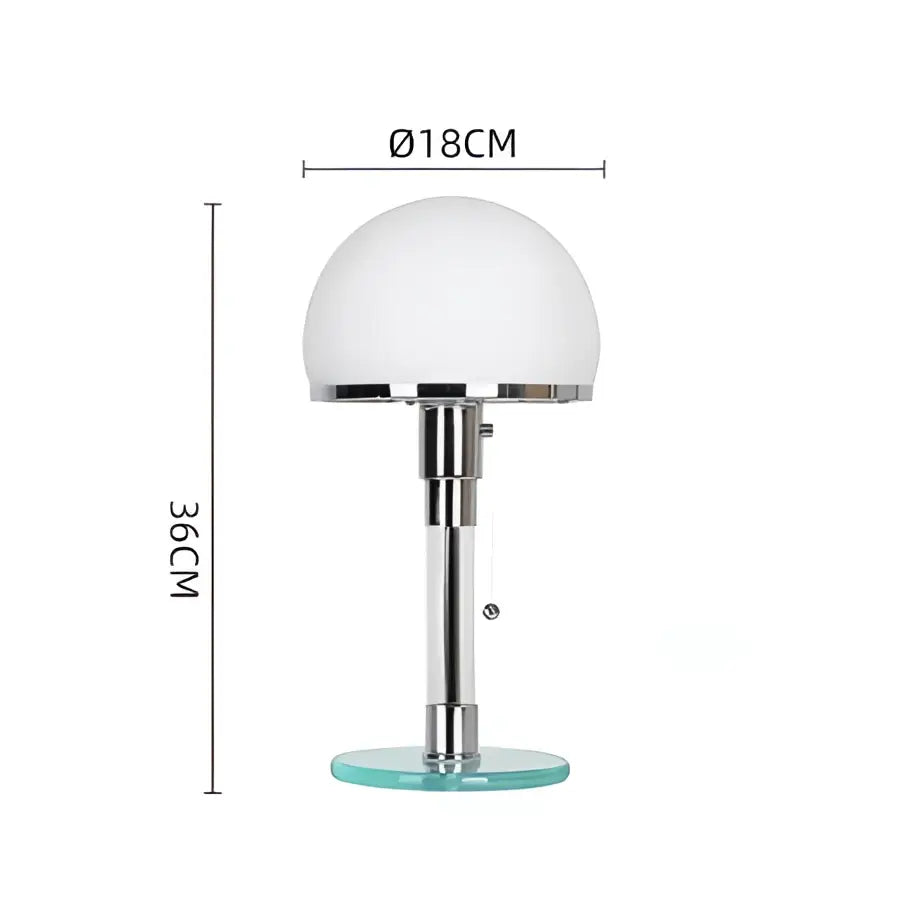 A bauhaus glass ball desk lamp with frosted white spherical shade and chrome stem on a clear base for bedroom use