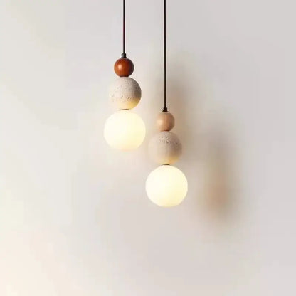 Two pendant lights feature tiered travertine stone and natural wood with warm glass globes that works beautifully in dining rooms