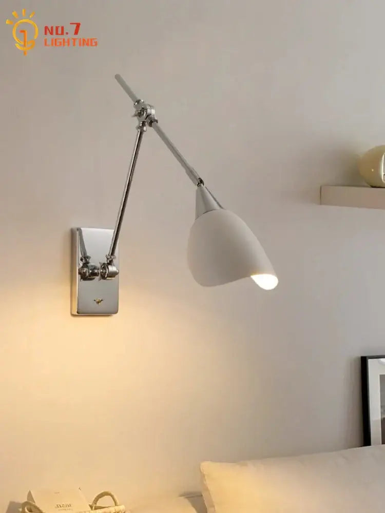 A bauhaus vintage swing arm wall lamp with chrome metal arm and base and white ceramic shade for living room use