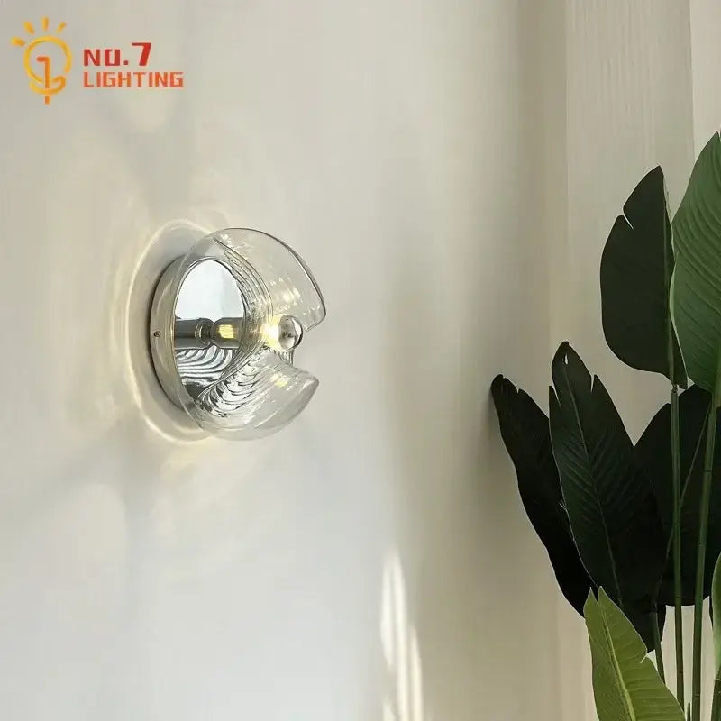 Clear glass bauhaus wavy glass wall lamp with chrome base and intricate wave-like ridges for bedroom lighting