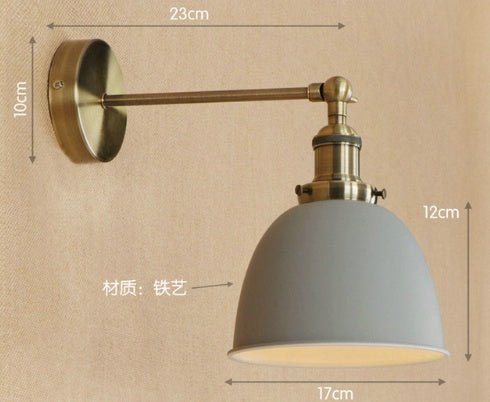 Gray metal bedroom wall sconce with adjustable arm and brass accents for versatile lighting solutions