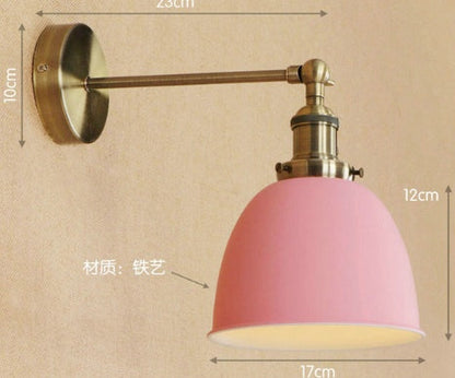 Pink wall sconce with brass accents and glass shade, iron material.