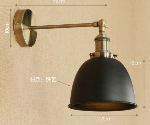 Black industrial-style wall sconce with brass accents and adjustable arm.