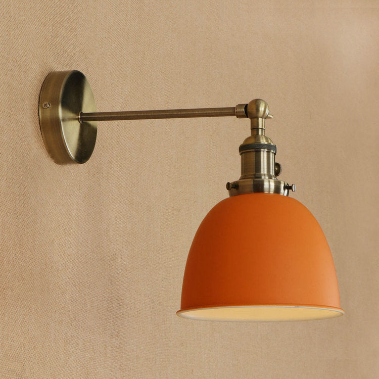 Orange dome-shaped bedroom wall sconce with brushed nickel finish and adjustable arm for flexible lighting