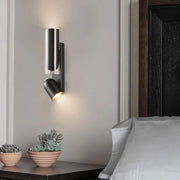 Modern brushed stainless steel bedroom wall reading lamp with sleek cylindrical body and adjustable spotlight head