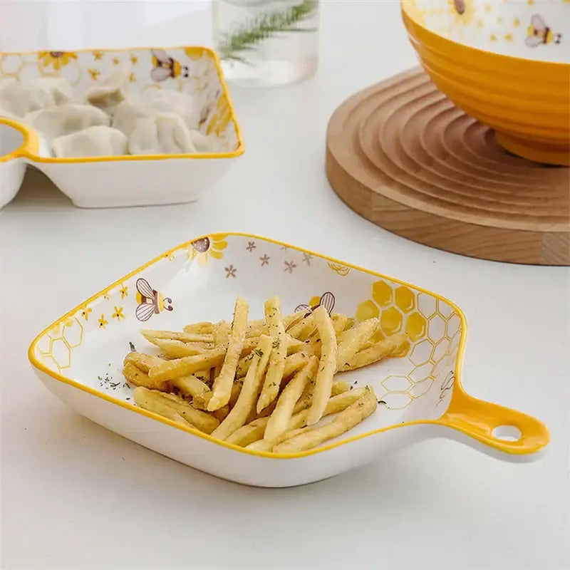 Yellow and white bee ceramic plate with honeycomb patterns and a handle for kitchen use