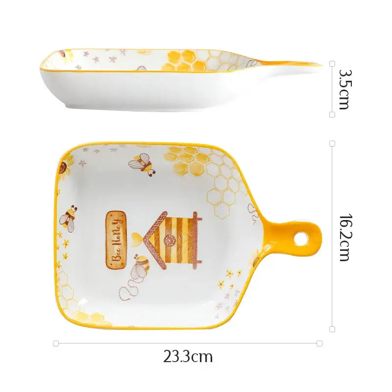 White and yellow bee ceramic plate with honeycomb handle featuring beehive illustration and be happy label