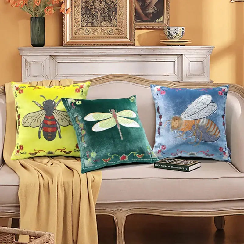 Three velvet cushion covers in yellow green and blue with bee embroidery and floral edge detailing for living room decor
