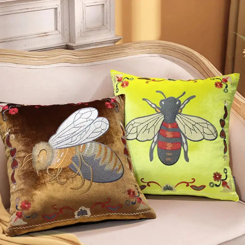 Two embroidered bee embroidery cushion covers in brown velvet and lime green for yellow green and blue living room decor