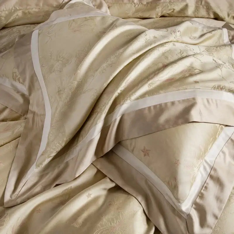 Cream-colored satin duvet cover with gold floral embroidery and white piping in beige and gold butterfly lyocell cotton bedding set