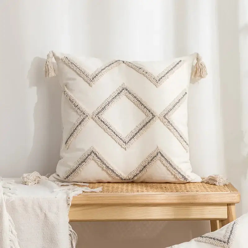 Beige and white cushion cover with decorbites geometric embroidery tassel design featuring black and beige woven lines