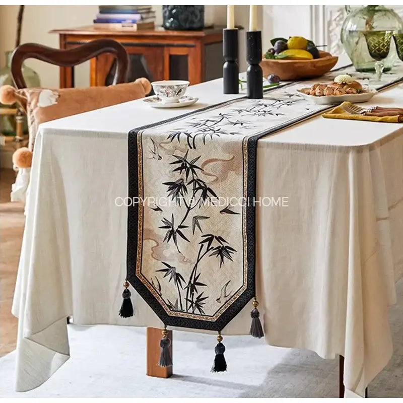 Beige table runner with black embroidered bamboo leaf swallow print and tassels for dining room decorbites bamboo leaf decor