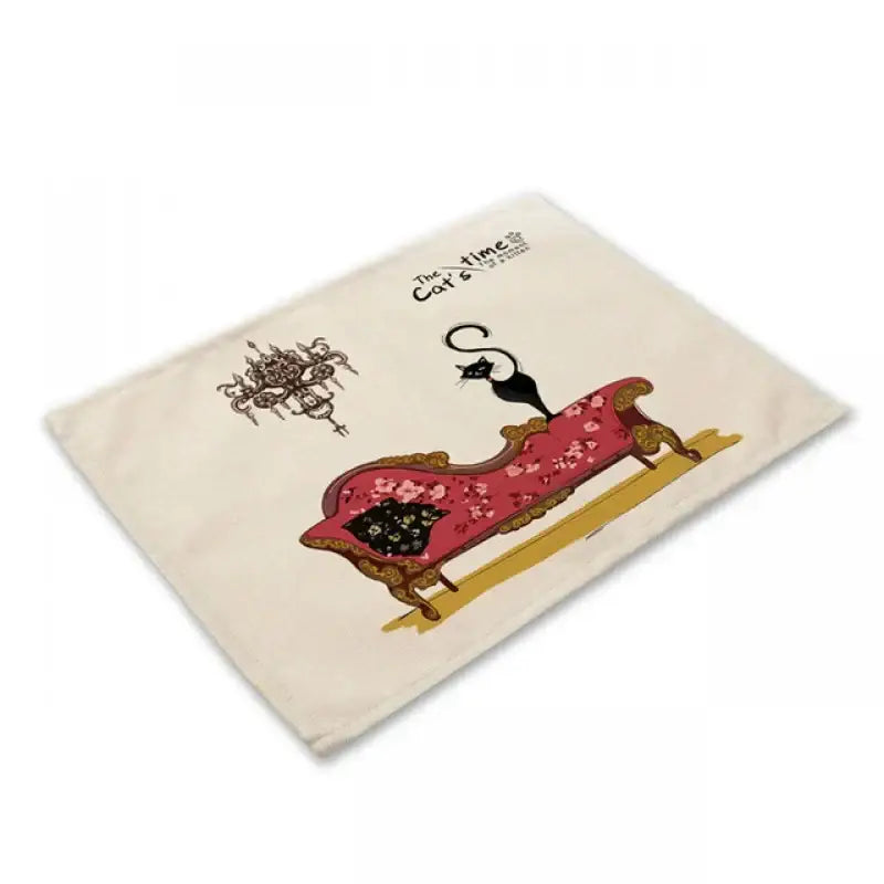 Cream-colored cotton placemat with whimsical black cat linen illustration on ornate red floral chaise for decorbites black cat table decor