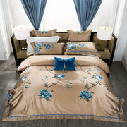Beige satin bedding set with intricate blue floral embroidery and royal blue velvet pillow accents egyptian cotton bedding