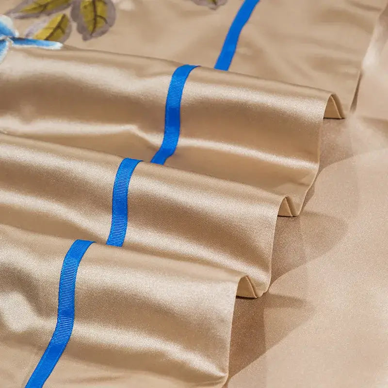 Beige satin pillowcases with blue ribbons and floral embroidery in embroidered egyptian cotton bedding set