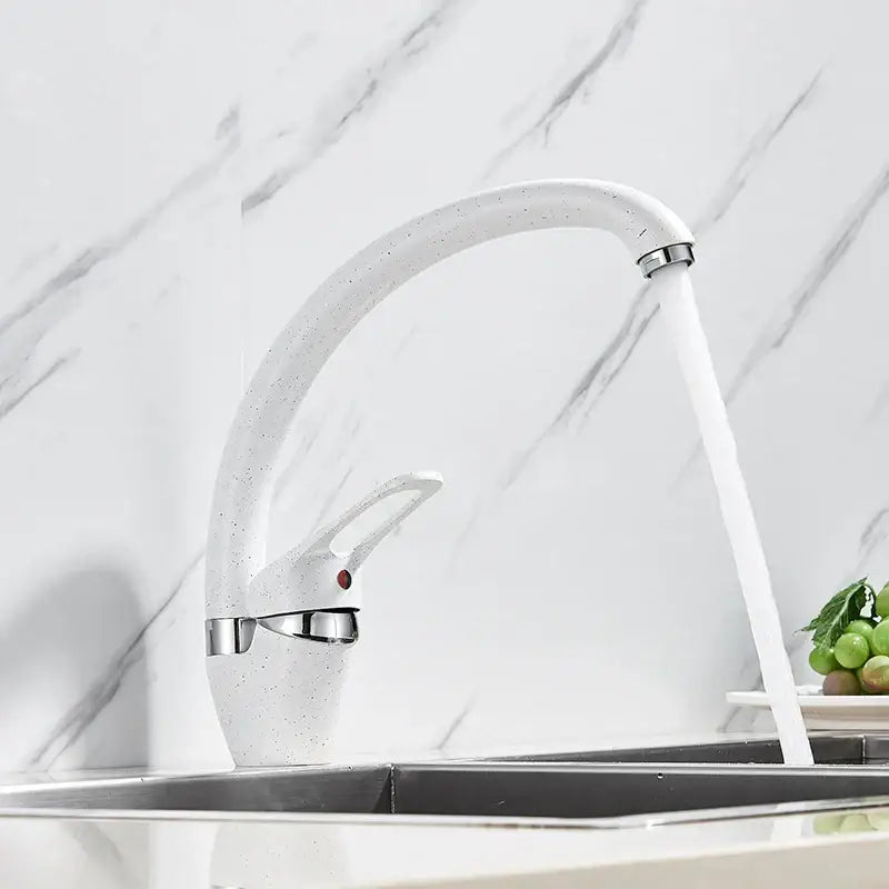 Beige brass kitchen faucet with white speckled ceramic body polished chrome accents and 360 degree swivel spout