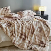 A beige and brown mottled faux fur decorbites cozy fleece throw blanket with a chunky textured weave for bedroom use
