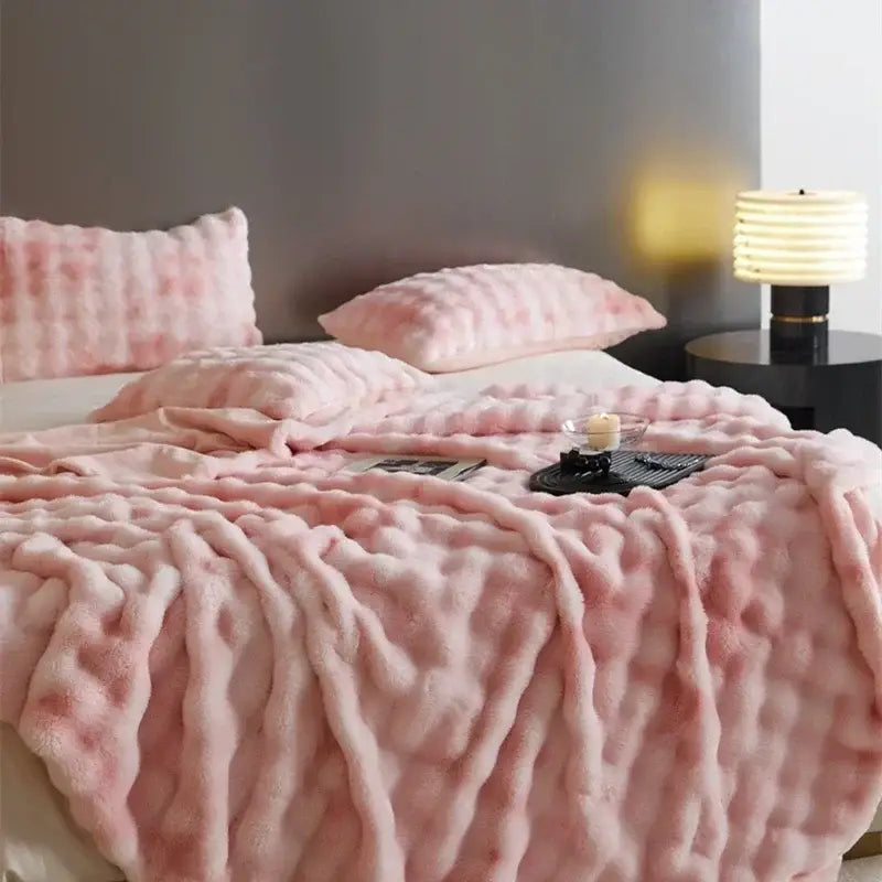 Pink plush throw blanket with textured fluffy surface made of decorbites cozy fleece for bedroom decor