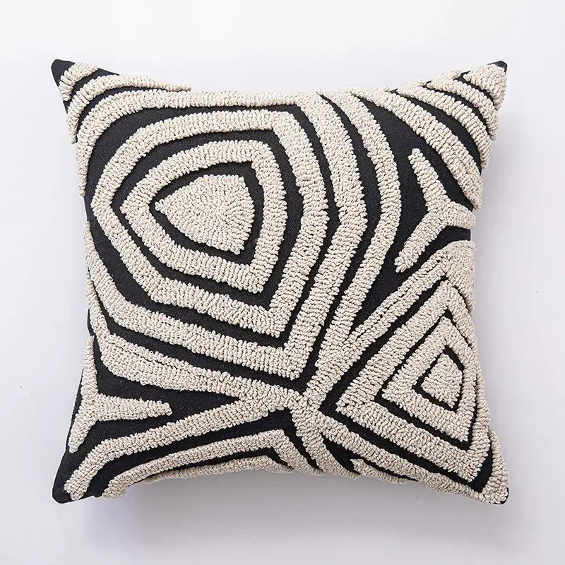 Black and cream-colored pouf pillow with tufted yarn texture featuring decorbites geometric line art cushion cover design