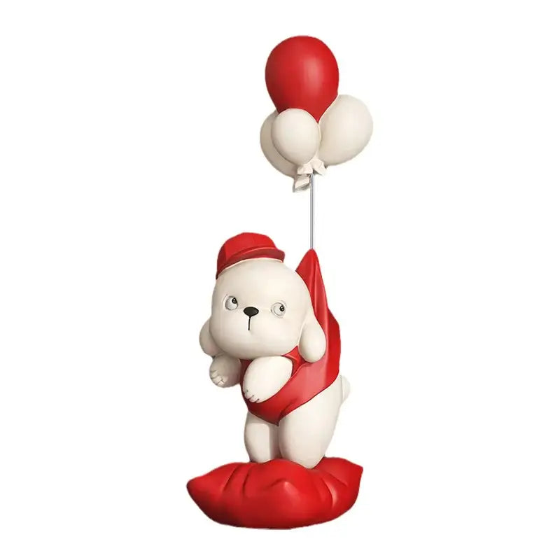 Beige ceramic balloon puppy statue featuring a white plush puppy with a red hat holding red and cream balloons on a red cushion