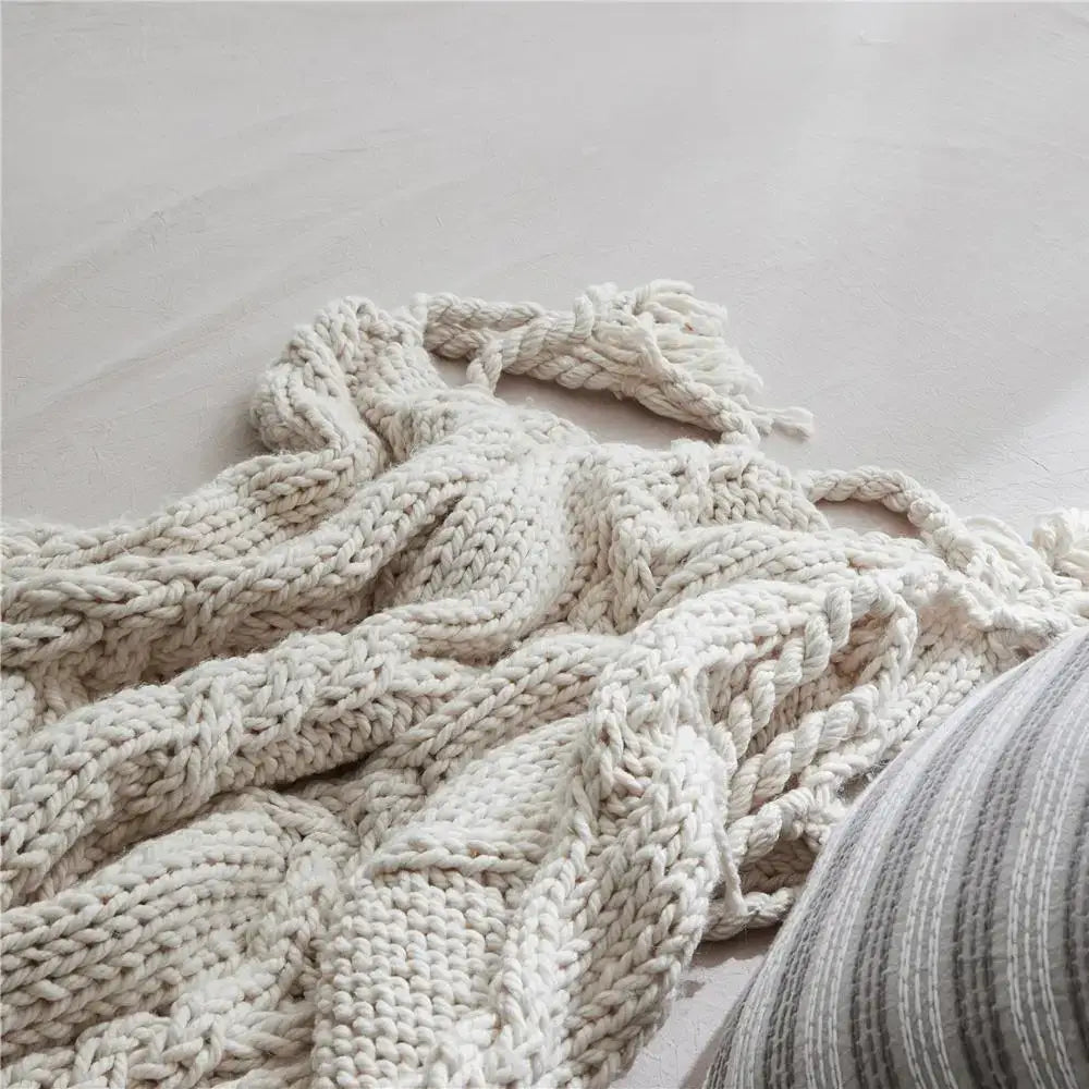 Cream-colored beige chunky knit tassel blanket with textured cable pattern and fringed edges for soft bedroom decorbites beige chunky throw