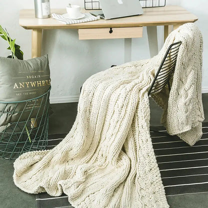 Beige chunky knit tassel throw blanket with cream cable pattern draped over black wire chair for decorbites beige chunky decor